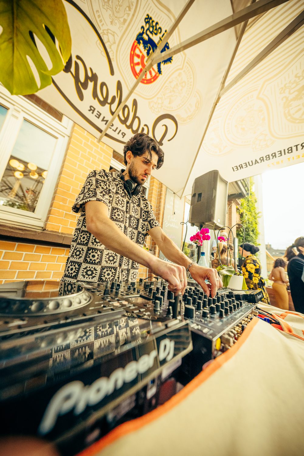 DJ an den Pioneer-Decks unter dem Sonnenschirm